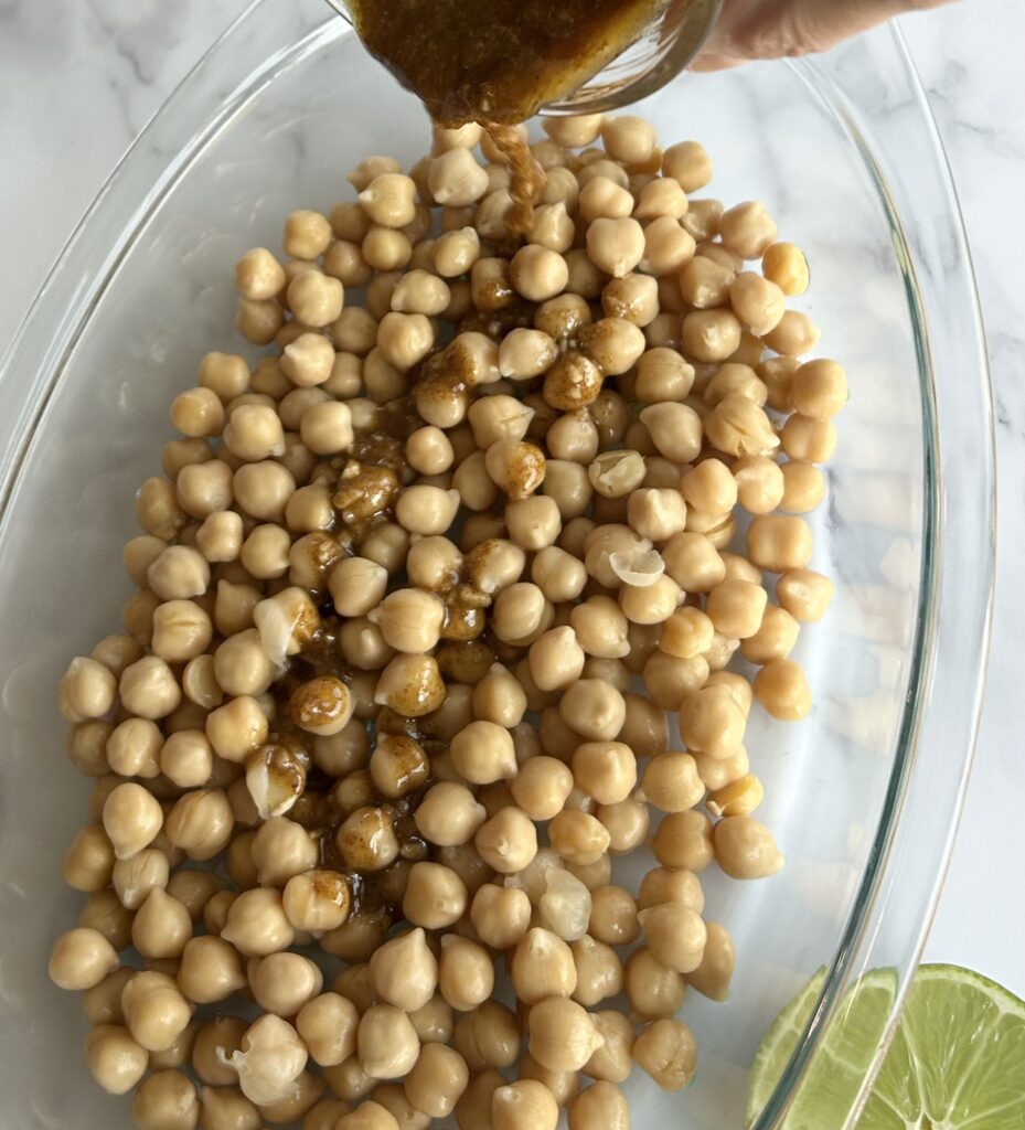 pouring seasoning into chickpeas