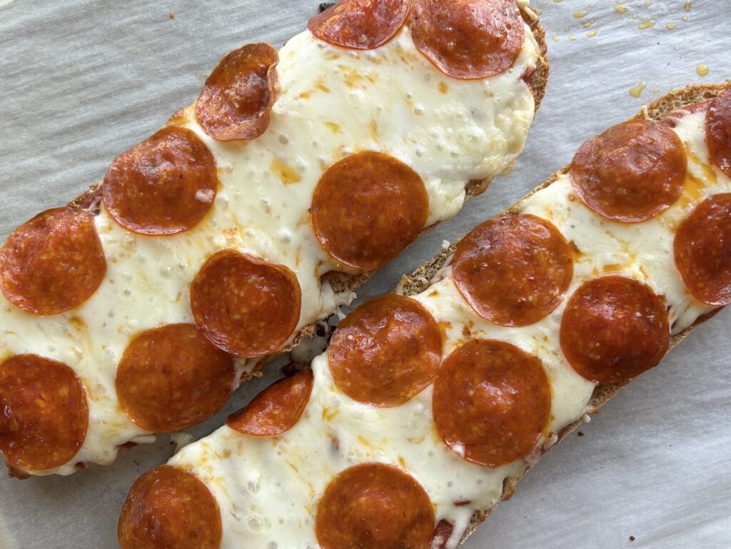French bread pizza after it is baked with melted mozzarella cheese and pepperoni.