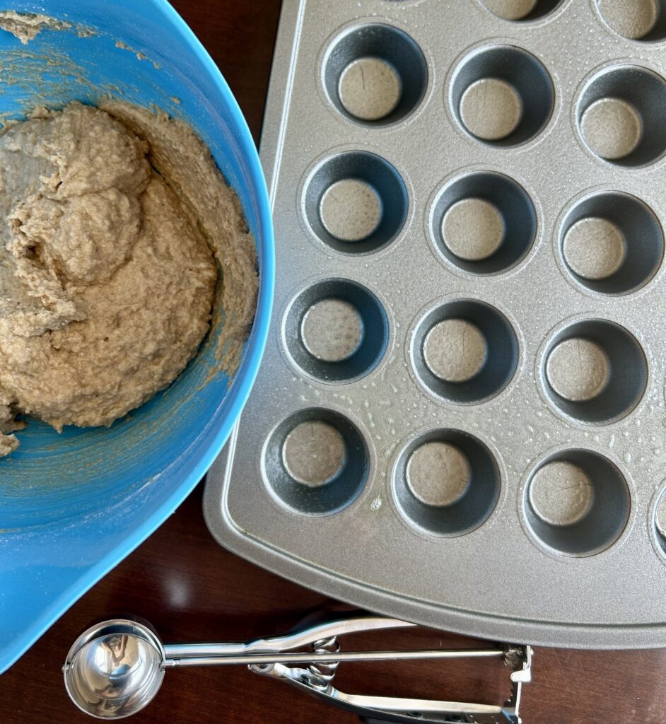 batter, muffin pan and scoop